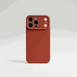 Apple iPhone silicone case in terracotta red with a smooth finish and raised camera protection around multiple lenses