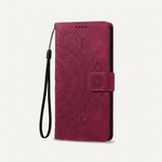 Apple iPhone wallet case in burgundy embossed leather with an ornate floral pattern, magnetic strap and wrist loop