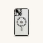 Apple iPhone case with a clear back, black bumper edges, and silver crystal accents around the camera and MagSafe ring