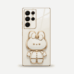 Samsung Galaxy phone case in glossy ivory with gold trim, featuring a raised bear character design and camera cutouts