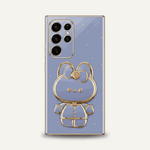Samsung Galaxy phone case in lavender with gold trim, jeweled accents, and a raised bear character stand
