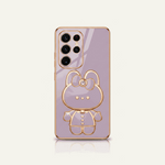 Samsung Galaxy phone case in lavender with a reflective finish and raised gold-tone bear character design with bow